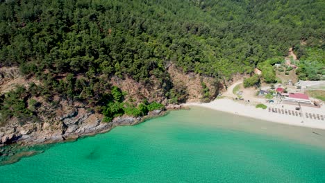 unveiling the serene paradise beach with turquoise waters, embraced by vibrant greenery and towering mountain peaks on thassos island, greece, europe