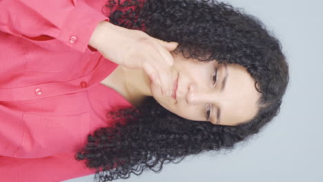 Vertical-video-of-The-young-woman-is-biting-her-nails.