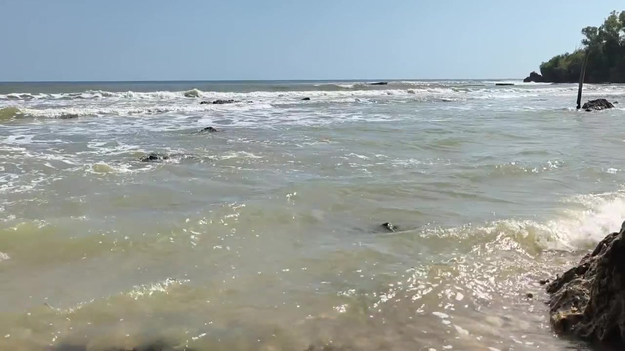 Ondas Suaves do Oceano Quebrando em uma Praia Tropical Rochosa