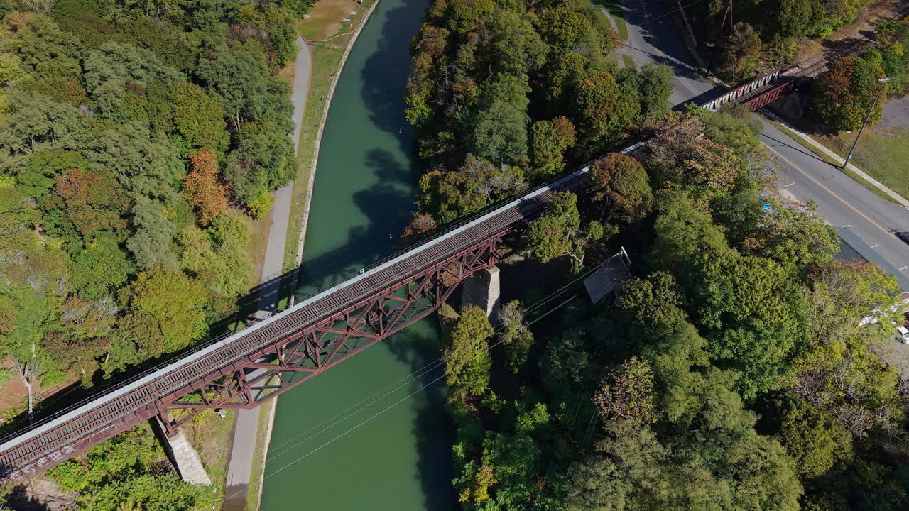Luftfoto af historisk jernbanebro over Erie-kanalen i Lockport, New York, USA med efterårsskov og kanalkorridor