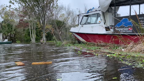 Damaged-scuba-boat-wrecked-against-seawall-aftermath-from-hurricane-storm