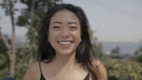 Closeup-of-Asian-girl-doing-funny-faces-and-smiling,-Slowmo