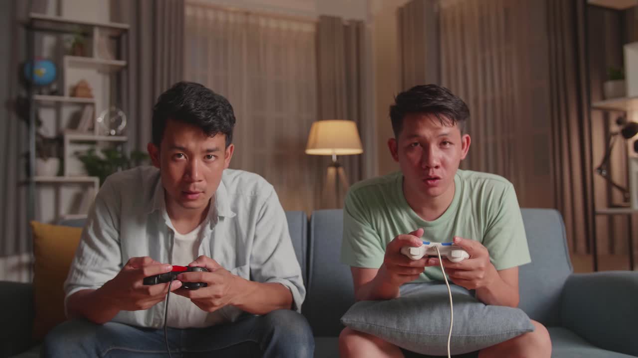 Asian Friends With Joystick Playing Video Games At Home.