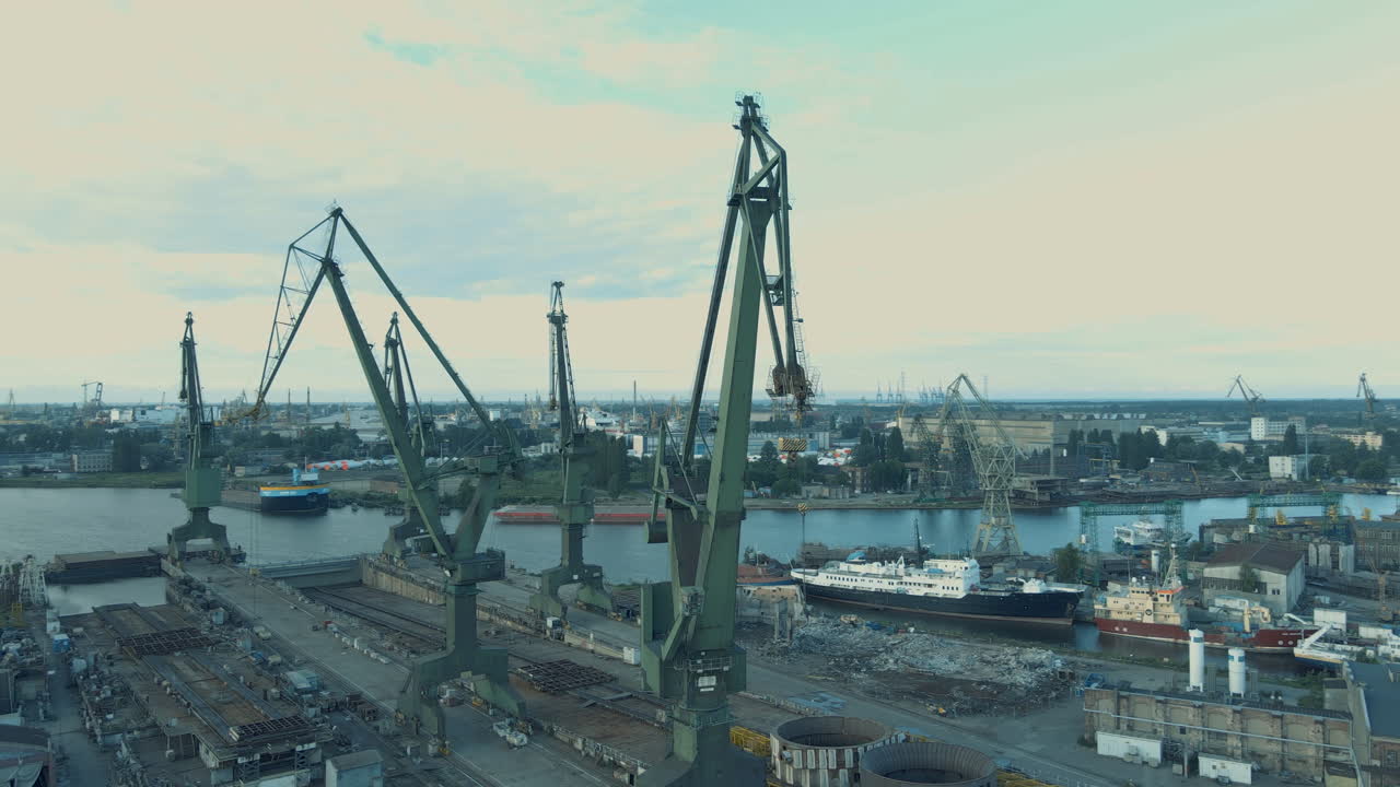 Aerial horizontal pan cranes in the shipyard, industry part of the city
