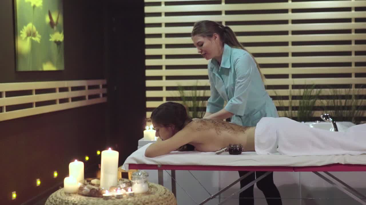 una mujer recibiendo un masaje de espalda en un spa.
