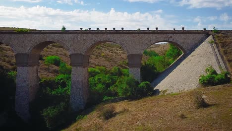 drone dolly-en movimiento de cámara sobre un antiguo puente viaducto de piedra amarilla, parte del ferrocarril medgidia-tulcea