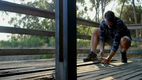 man removing hardwood floors of cabin porch 4k