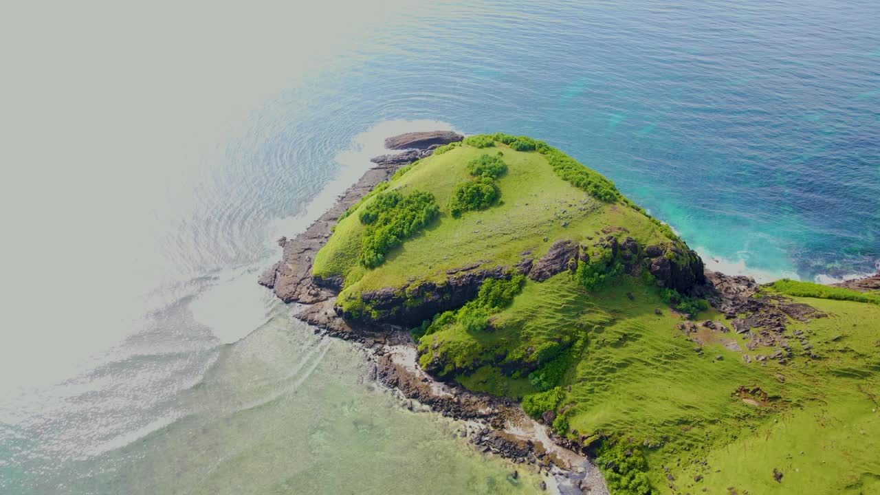 Letecký pohled na svěže zelené pobřeží ostrova s průzračným modrým oceánem