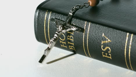 rosary beads falling onto bible