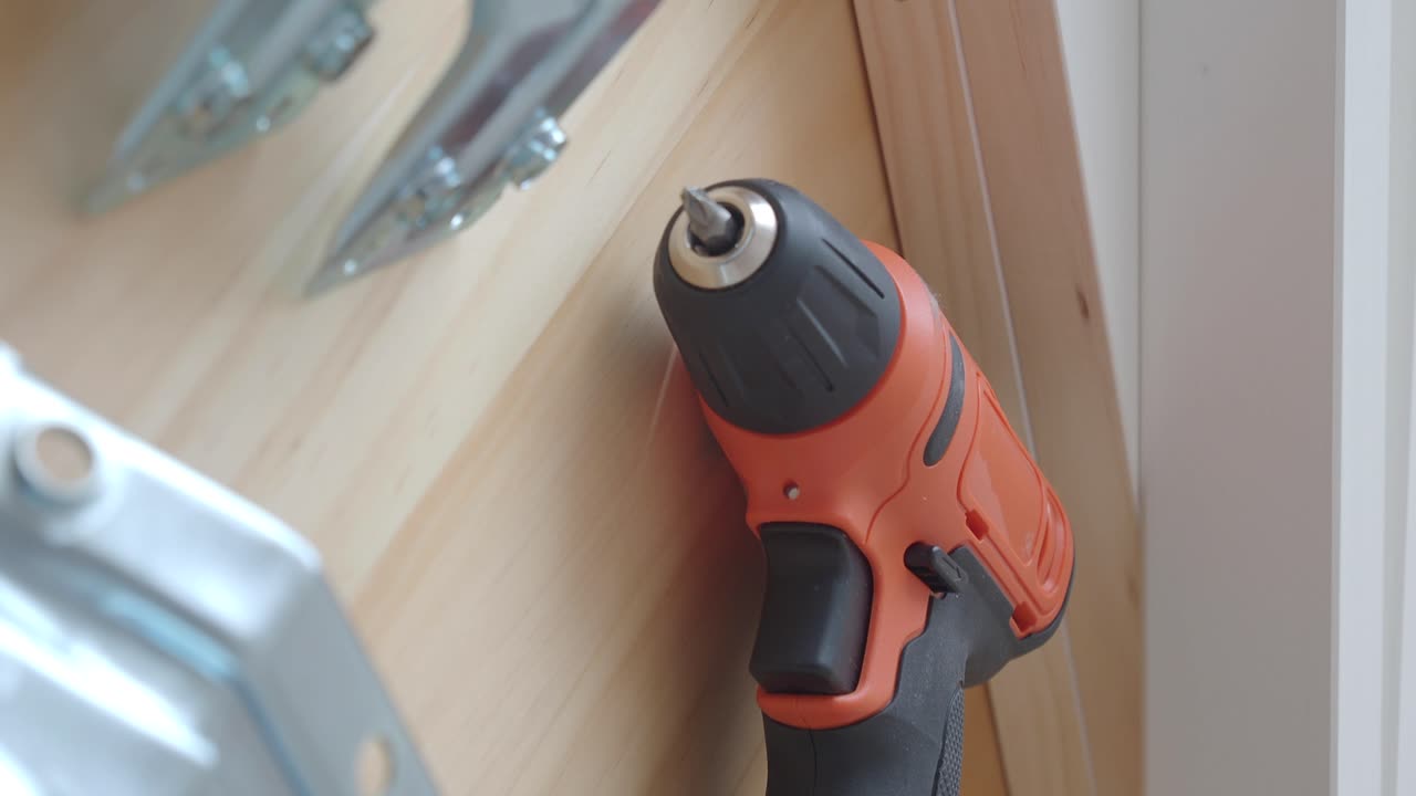 Orange Electric Drill on Wooden Surface with Other Tools