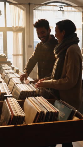 happy couple browsing vinyl records in a store
