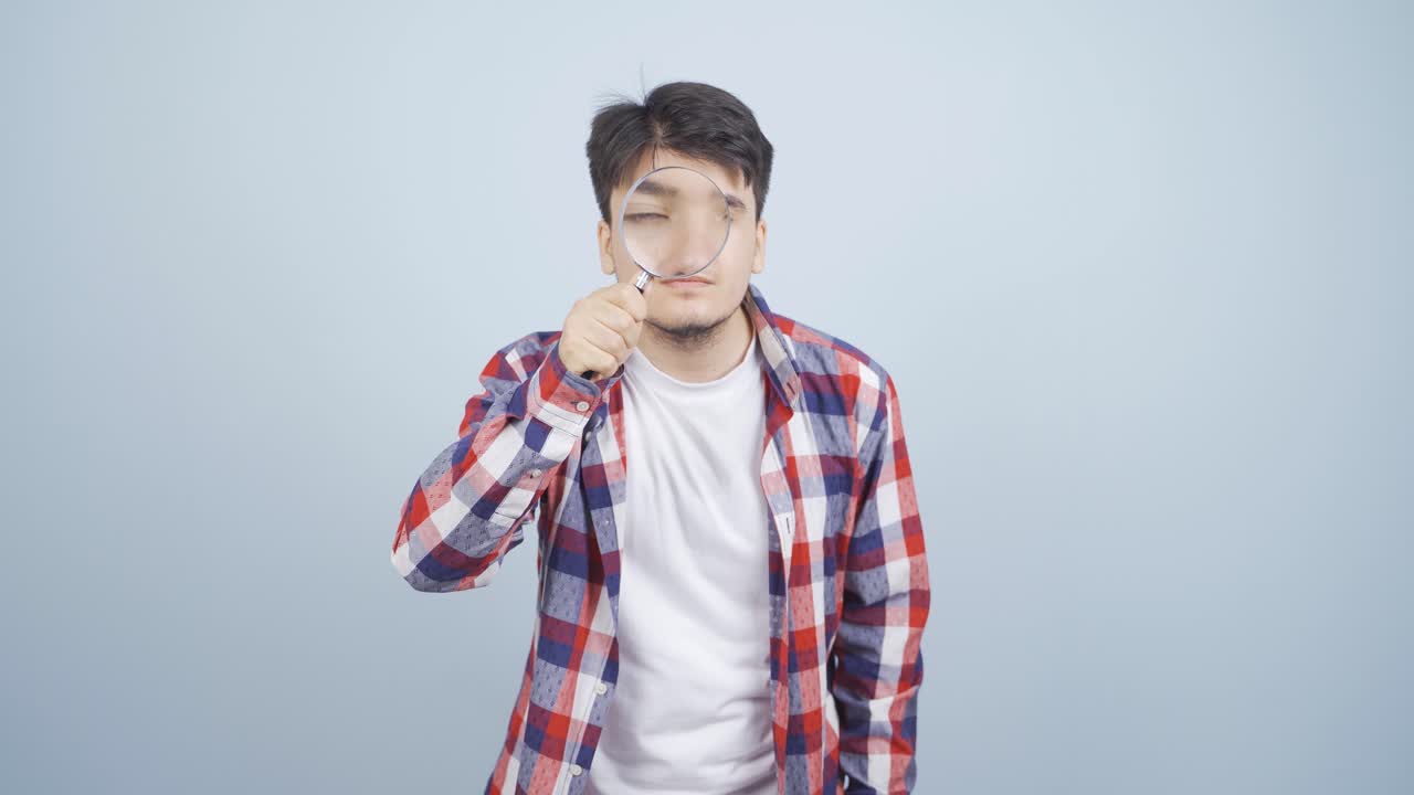 커다란 유리창으로 카메라를 보는 남자.