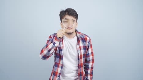 커다란 유리창으로 카메라를 보는 남자.