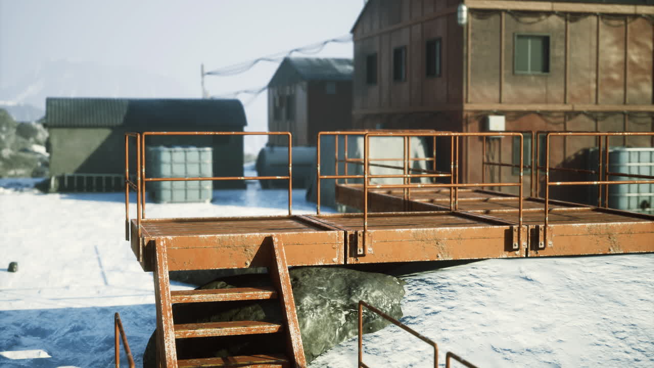 plataforma industrial cerca de edificios cubiertos de nieve en un lugar remoto