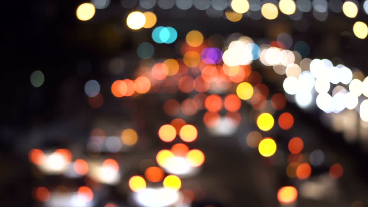 hermoso bokeh redondo colorido de los faros de los coches en la carretera por la noche