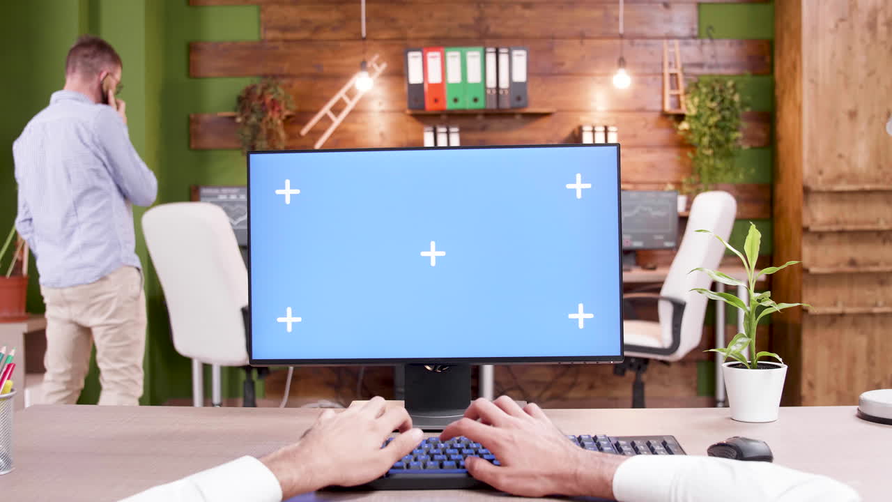 Office Setup with Chroma Key Monitor and Person Typing