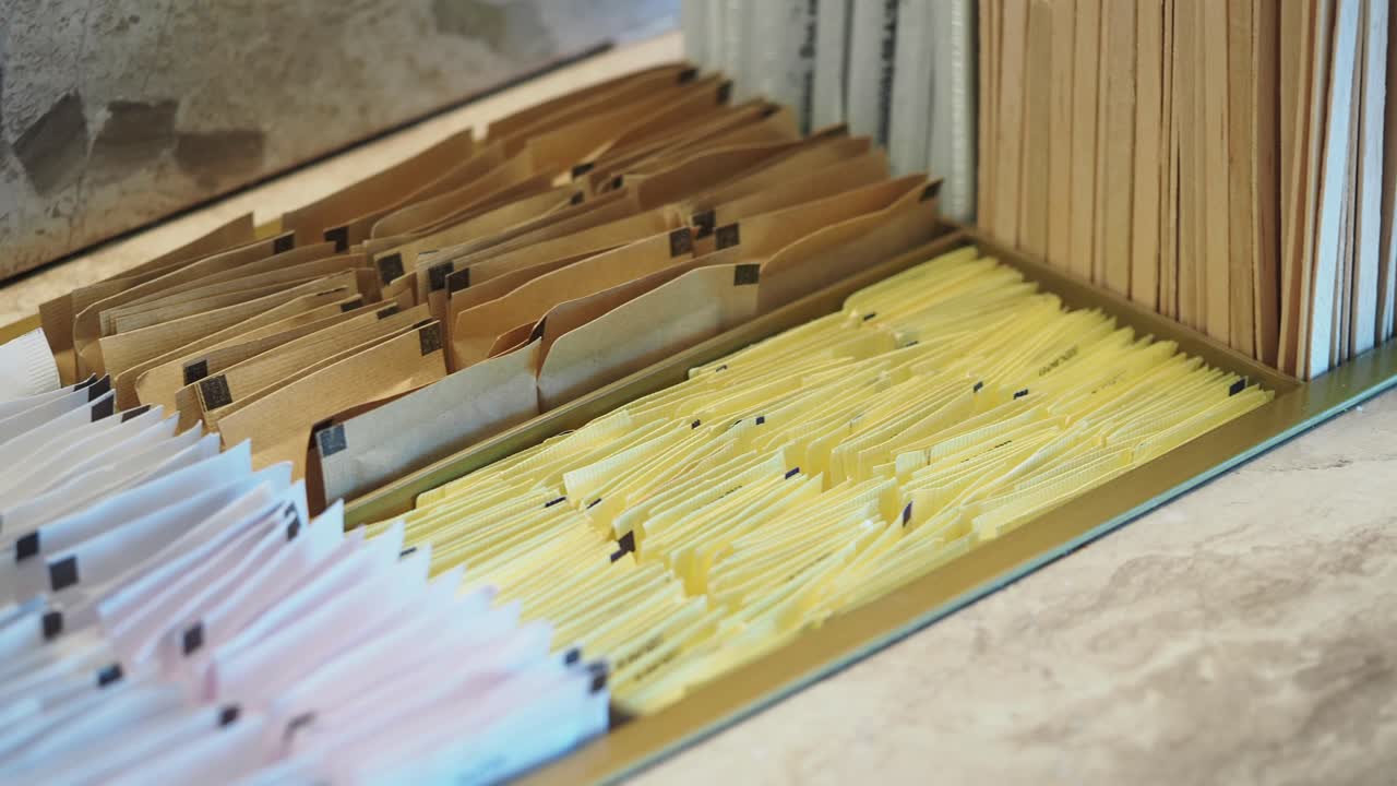 Organized Assortment of Sugar Packets and Stirrers