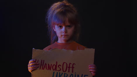 upset homeless girl kid protesting war conflict raises banner with inscription hands off ukraine