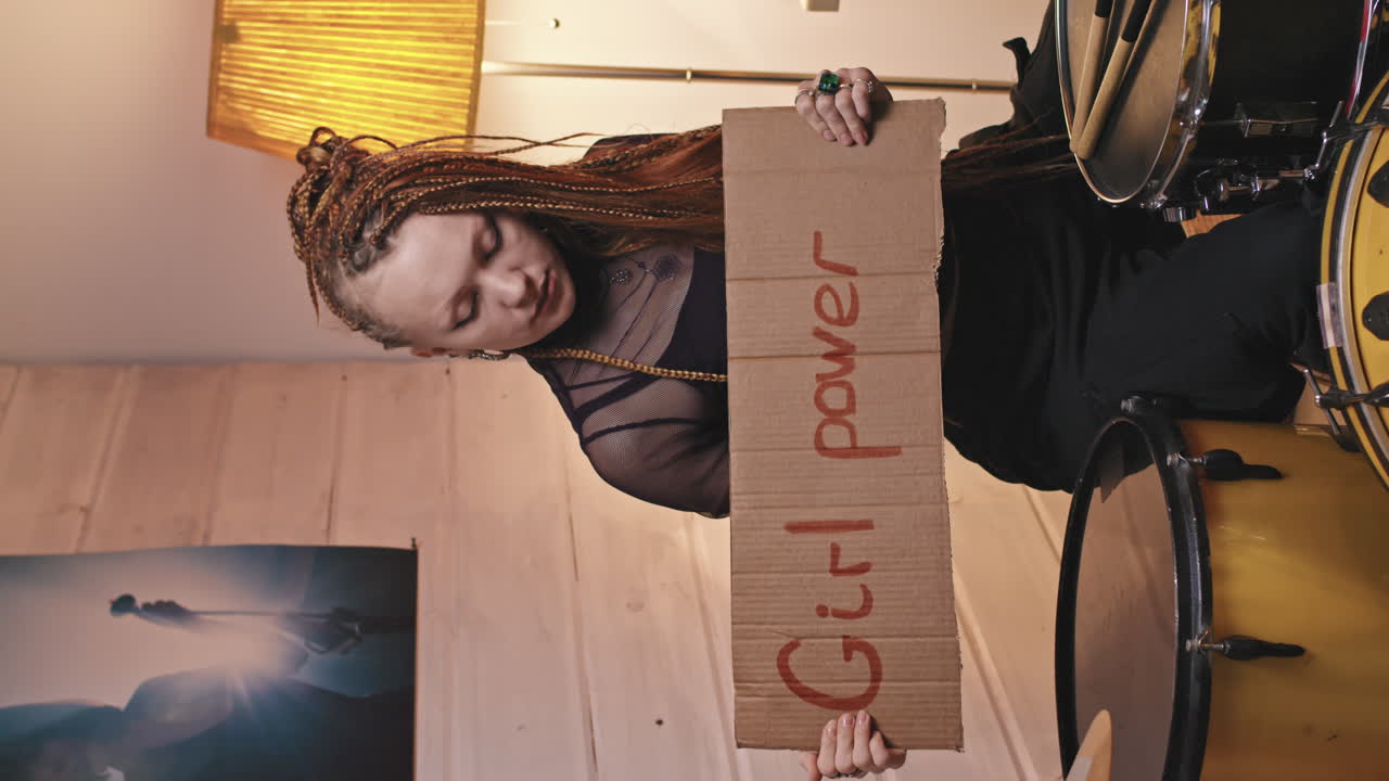 Rock-n-Roll Female Drummer Holding Feminist Sign