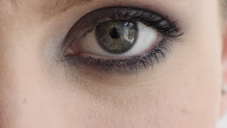 cerrar la apertura de los ojos de una mujer joven que usa maquillaje en la cámara parpadeando cosméticos de belleza