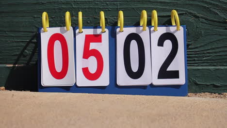 scoreboard blows in wind at baseball softball kickball game in sliding motion