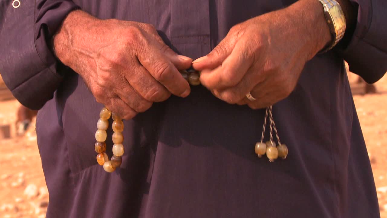 Tilt up to a close up of the face of a Bedouin man in Palestine