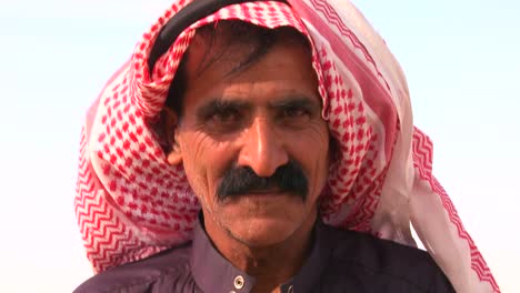 tilt up to a close up of the face of a bedouin man in palestine