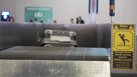 cinta transportadora de equipaje de aeropuerto con señales de advertencia