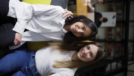 una niña y su mentora femenina en blusas blancas posan para la cámara