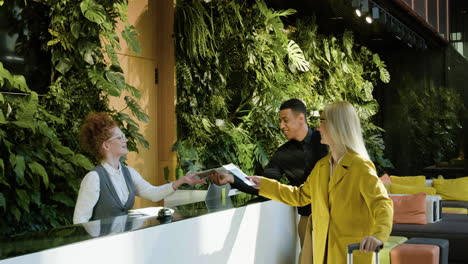 redheaded receptionist sitting behind the counter of a hotel