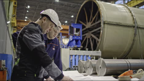 industrial engineers reviewing plans in a factory