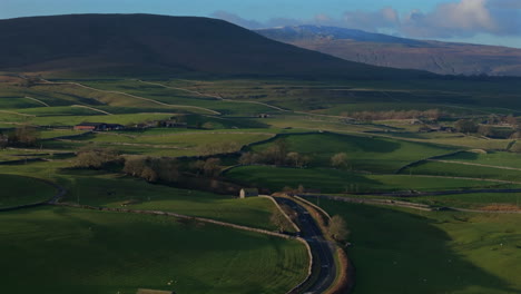 establishing drone shot of yorkshire dales farmland landscape at sunset