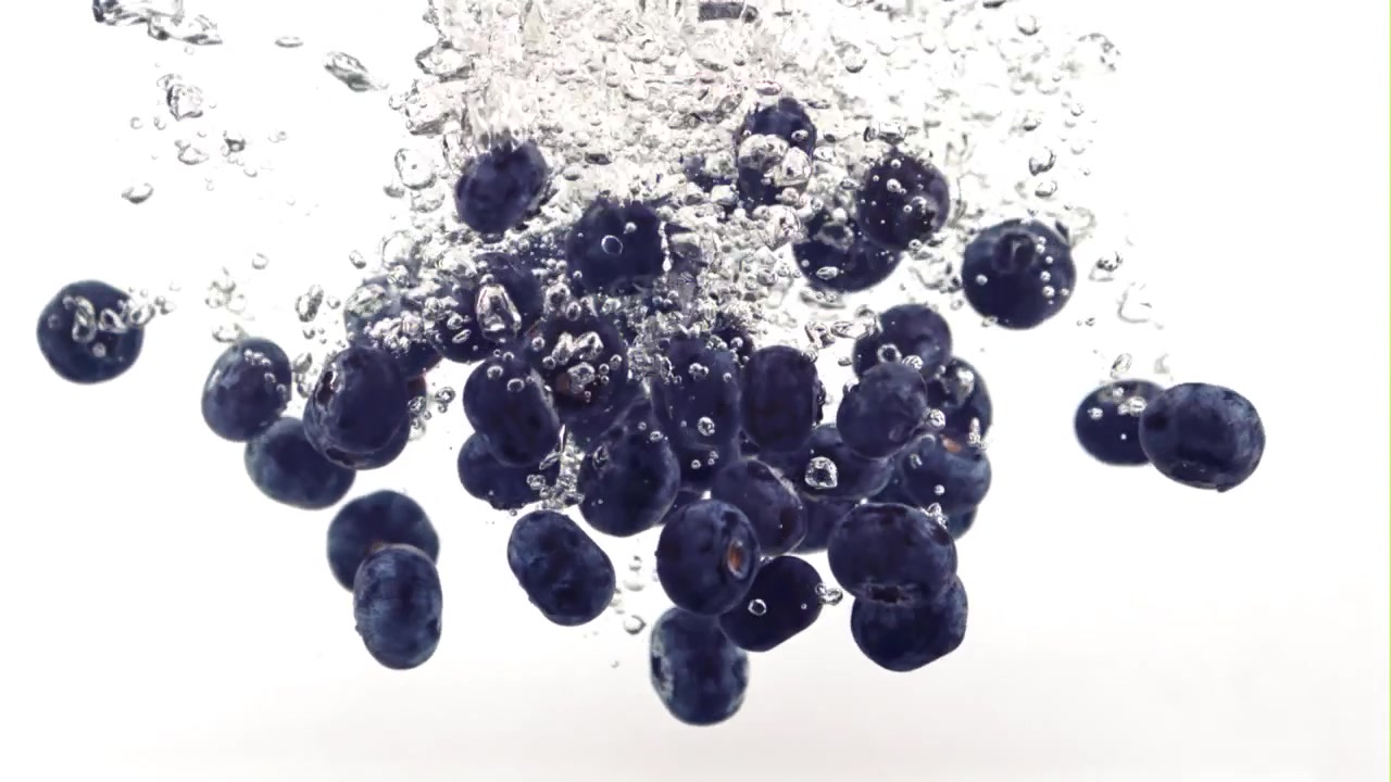 Färska blåbär som faller ner i klart vatten i slow motion