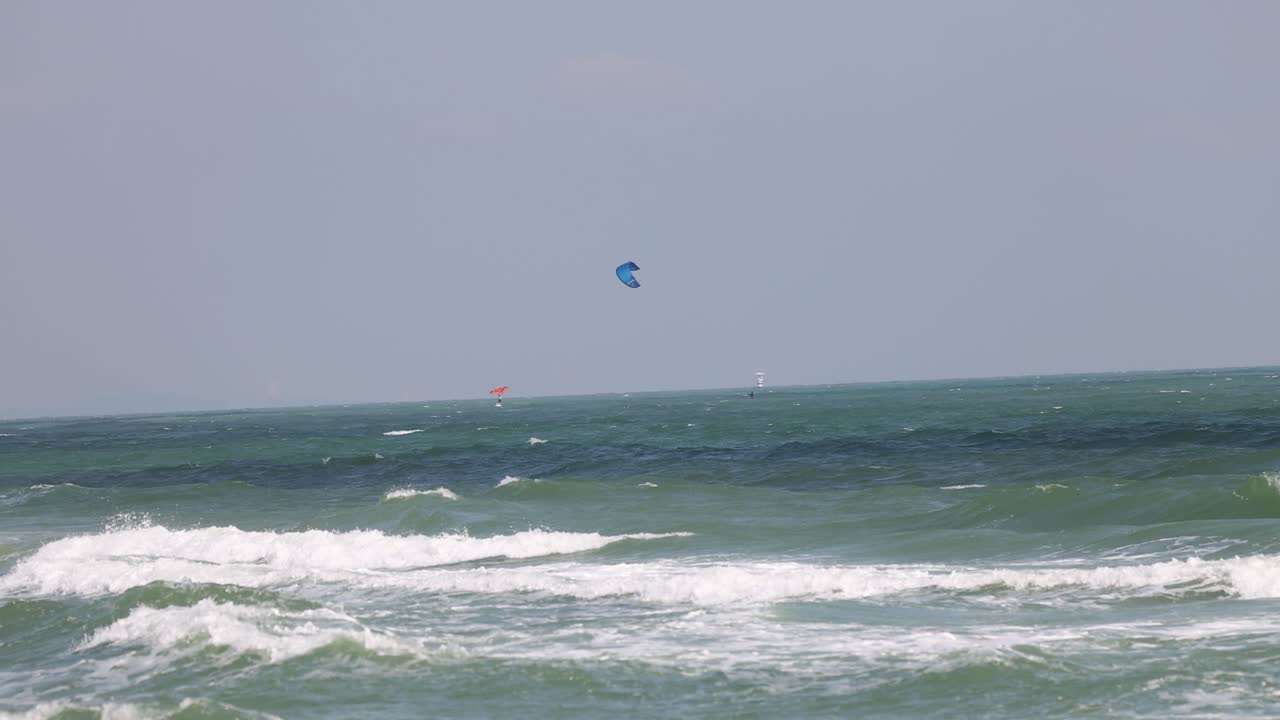 카이트 서퍼 들 은 푸른 하늘 아래 파도 를 타고