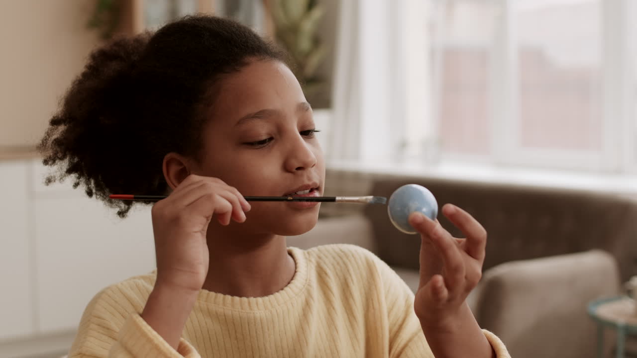 Girl Painting Egg in Color Blue