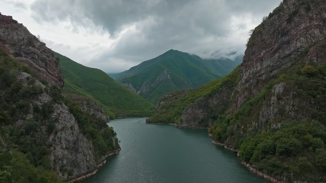 Moody Cloudy Sky Over Serene Komani Lake Surrounded By Mountains In Albania. aerial shot
