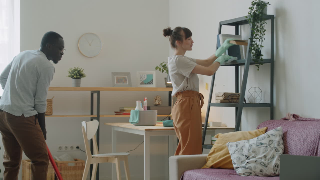 젊은 다민족 부부 가 함께 집 을 청소 하고 있다
