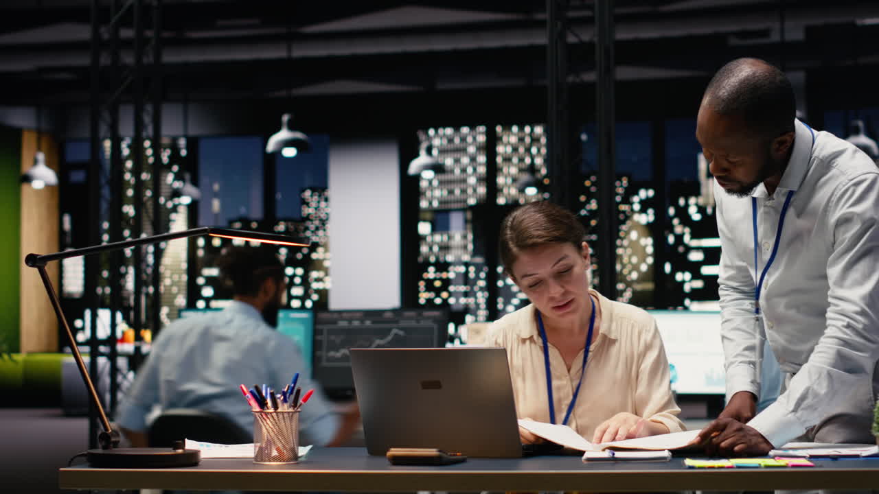 Time-lapse af CEO og medarbejdere, der analyserer data sammen på kontoret sent om natten