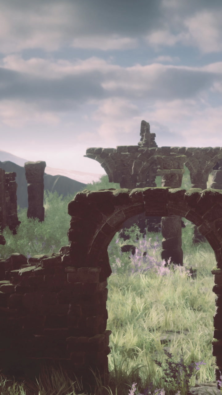 Ancient stone ruins stand amidst green grass and mountains in clear sky
