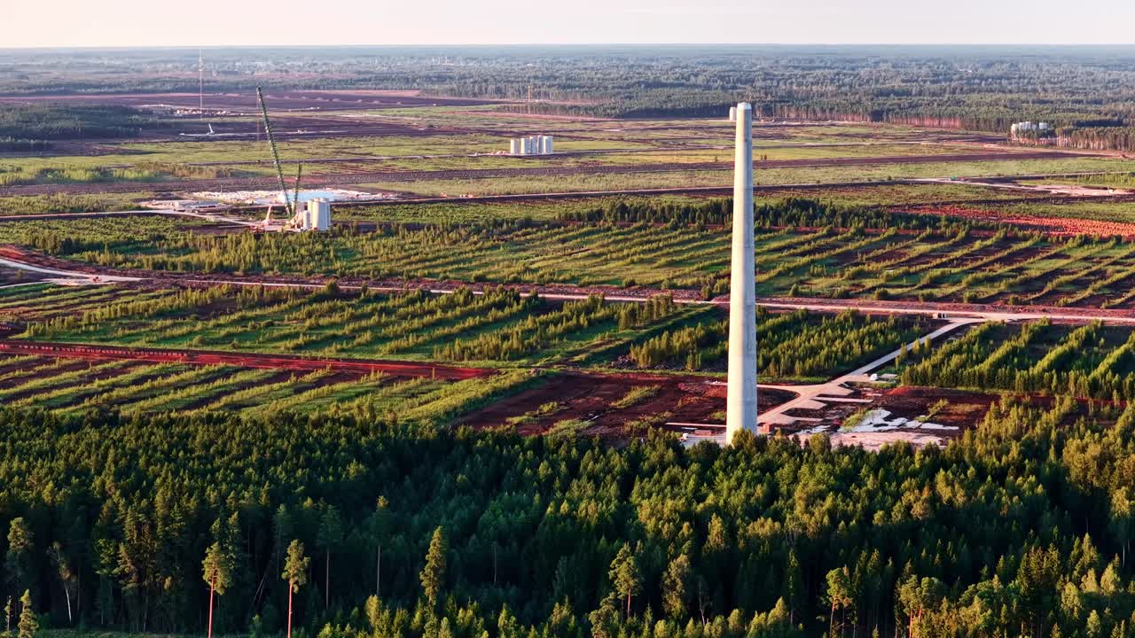 Bird’s eye view of a windmill pylon under construction in a forest environment