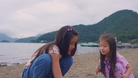 두 명의 어린 소녀들이 호수 해변에서 시간을 즐기고 있습니다.