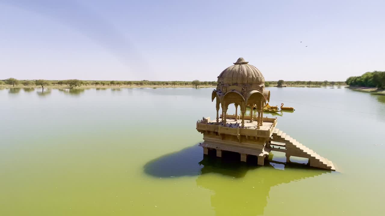 Gadsisar Lake in Jaisalmer shimmers under the Rajasthan sun, reflecting ancient temples and serene pavilions. Golden light, calm waters, and migratory birds add to its timeless desert charm