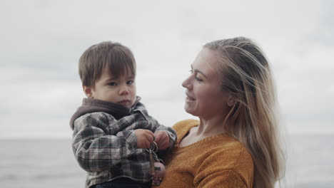 una joven madre camina con su hijo por las orillas del pintoresco lago ontario