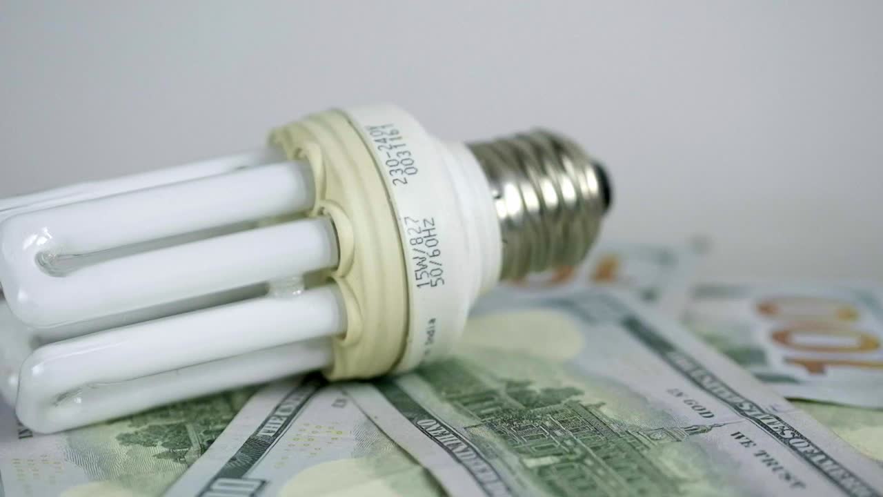 la bombilla gira en las facturas de 100 dólares. aumento de las tarifas de electricidad.