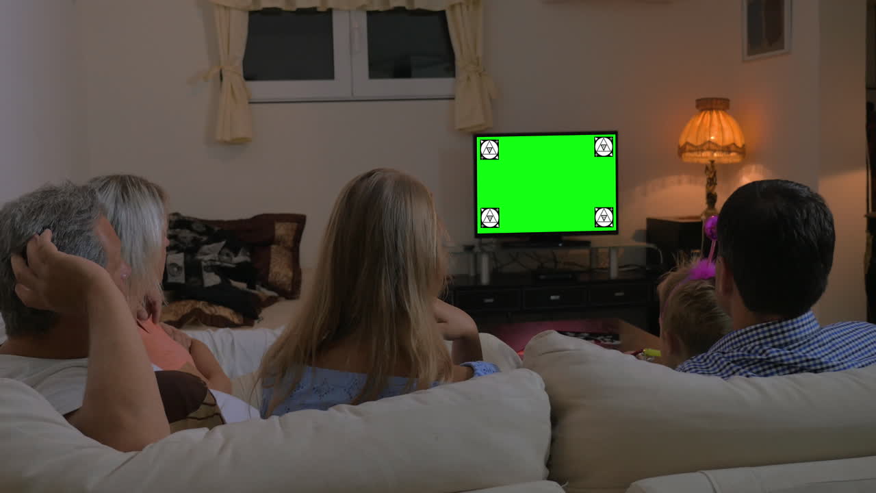 Famiglia che guarda la TV a casa con chroma key