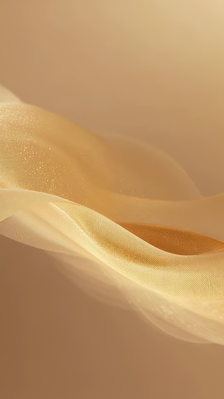 Video verticale: pura seta dorata cangiante che ondeggia su uno sfondo beige da studio, con piccoli riflessi
