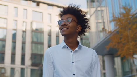 portrait of young afro american businessman standing outdoors business center
