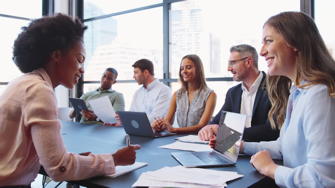 Multi-Cultural Business Team Meeting Around Office Boardroom Table With ...