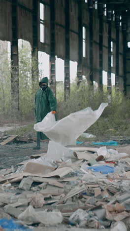 man in chemically protective clothing. human in gas mask walking among ruins