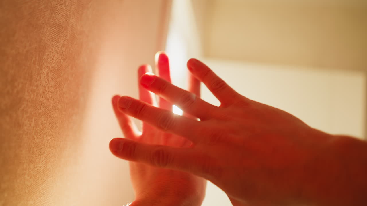 pov juego de manos a la luz del sol, los dedos crean patrones contra los rayos cegadores, la cámara de mano captura el brillo cálido